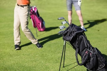 Low section of couple playing golf