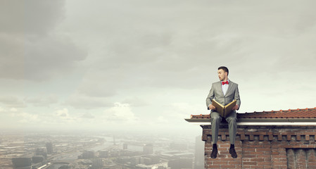 Fototapeta premium Businessman reading old book . Mixed media