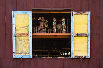 Traditional handicraft wooden doll in old window, Myanmar