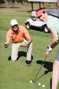Portrait of smiling couple playing golf 