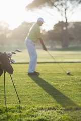 Full length of man playing golf while standing on field 