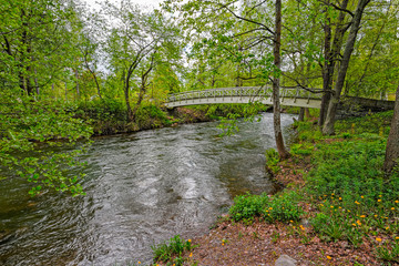 Fototapeta premium Pedestrian wooden bridge over stream
