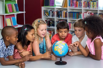 Children looking at globe on table