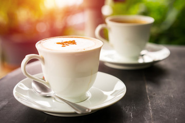 Hot latte coffee on wood table in garden