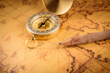 Old  gold vintage compass and pencil on vintage map