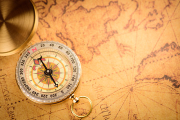 Naklejka na ściany i meble Old gold vintage compass and pencil on vintage map