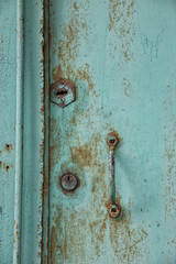 old rusty shabby metal green door with metal handle and door lat