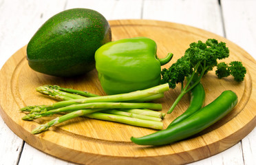 Green vegetables on wooden board.