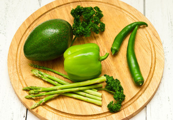 Green vegetables on wooden board.