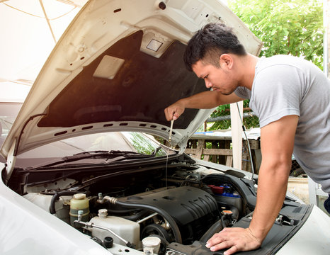 A Man Checking Car Engine At Home