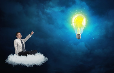 Obraz na płótnie Canvas Man sitting on cloud looking at a lightbulb