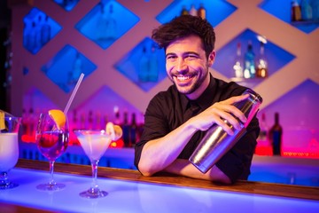 Bartender smiling while holding cocktail shaker