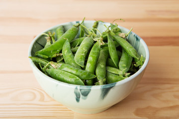 green pods with peas as background