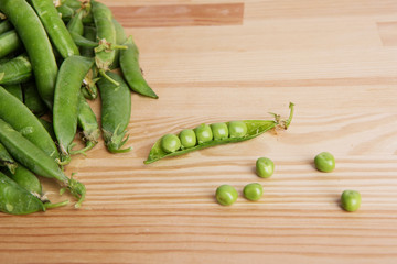 green peas in pods freshly picked on wood.