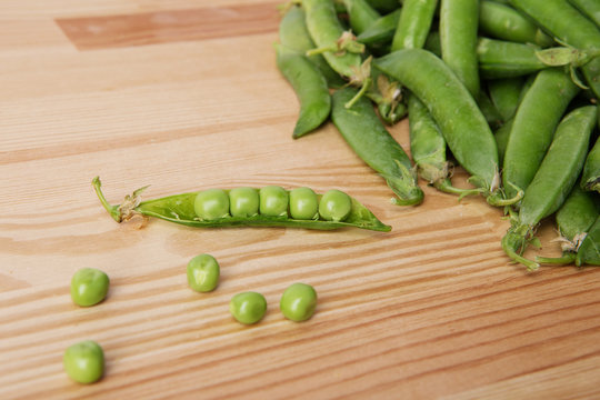 green peas in pods freshly picked on wood.