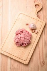 minced pork uncooked with garlic  on wood block