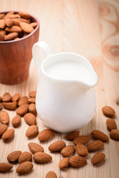 Almond milk in a jar with almond on a wooden table