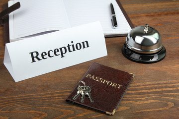 a passport with a bunch of keys lying on the reception on a wooden table