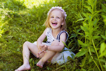 Very happy little girl laughing in grass © julijacernjaka