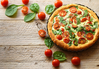 Summer outdoor tart, pie of fresh vegetables - tomatoes, spinach and red onion with cream and...