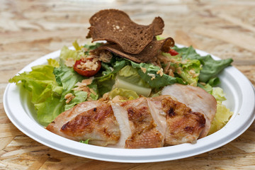 Plate with grilled turkey, salad and bread closeup