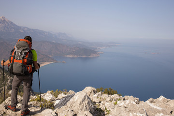 Young man with backpack on a mountain top.