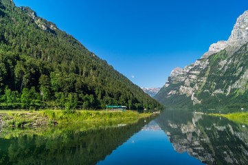Fototapeta na wymiar Wunderschöner Sommertag am Klöntalersee mit Bergen und blauen Himmel