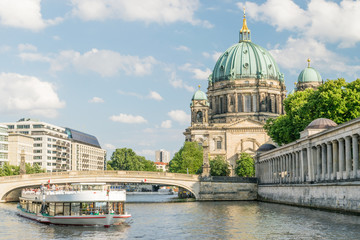 Fototapeta na wymiar Berlin Cathedral at famous Museum Island with excursion boat river