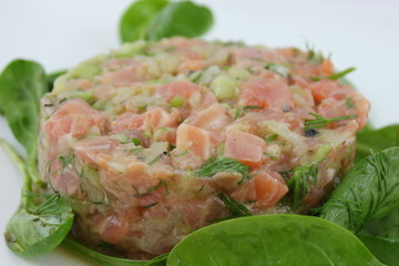 Tartare de saumon sur un lit de feuilles d'épinard