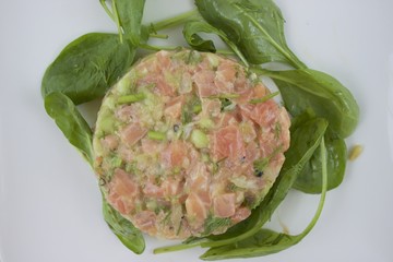 Tartare de saumon sur un lit de feuilles d'épinard