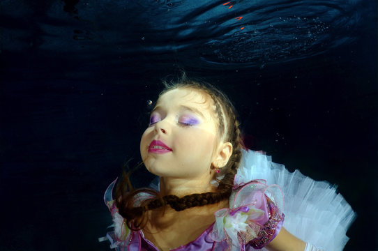 Girl presenting underwater fashion in pool