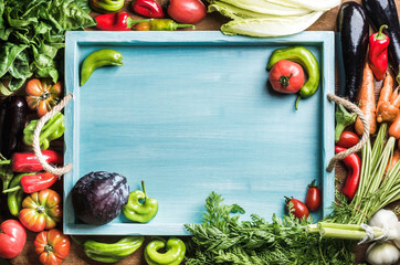 Fresh raw ingredients for healthy cooking or salad making with blue wooden tray in center, top view, copy space © sonyakamoz