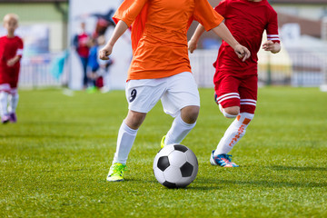Fototapeta premium Kids of young soccer football team. Boys kicking soccer ball on a pitch.