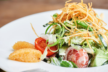 Salad of pike caviar and vegetables served on white plate