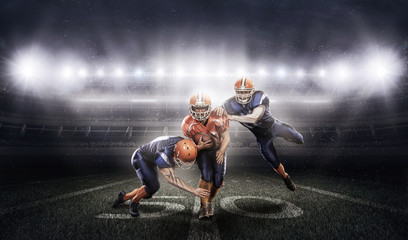American football players in action on stadium with ball