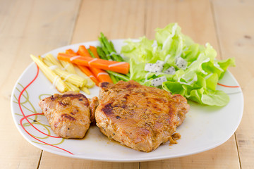 Grilled steaks on dish with salad