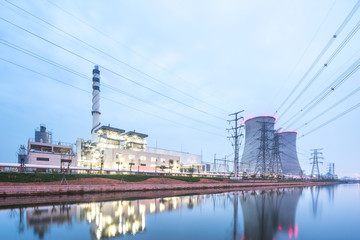 Fototapeta na wymiar modern factory near river in blue sky at dawn