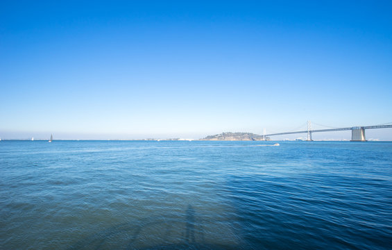 landmark bay bridge over tranquil sea in blue sky