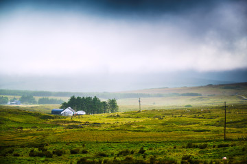 Fototapeta premium Rural misty landscape with village houses. County Donegal, Ireland