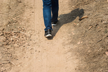Men wear jeans and wear walking shoes on the ground.