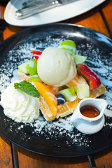 waffle with fruit,ice cream,and syrup