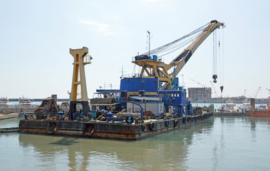 Самоходный плавучий кран в порту