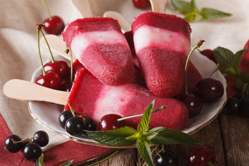 Popsicle with mint and cherry on a stick close-up on the table. horizontal
