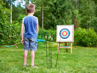 Little boy with big bow near sport aim
