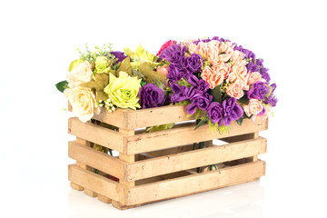 Wooden box with plastic flowers on white background ,selective focus