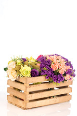 Wooden box with plastic flowers on white background ,selective focus