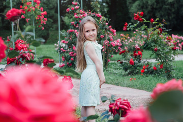 Beautiful little girl in the blooming garden 
