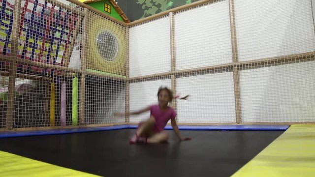 A girl jumping on a trampoline at an entertainment park
