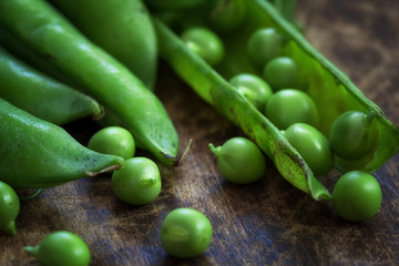 Organic green peas on wooden table 