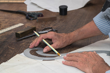 A tailor's work table with cloth for a jacket cut and marked up for sewing.
